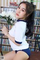 A woman sitting on a table holding a bunch of flowers.