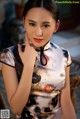 A woman in a cheongsam posing for a picture.