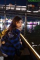 A woman sitting on a boat with a teddy bear.