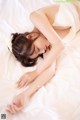 A woman laying on a bed in a white lingerie.