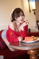 A woman sitting at a table with a plate of fruit.