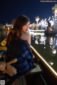 A woman sitting on a boat with a teddy bear.