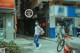 A woman wearing a face mask walking down a street.