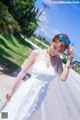 A woman in a white dress is walking down the street.