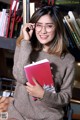 A woman sitting on a chair holding a book.