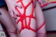 A woman is tied up with a red string.