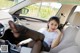 A woman sitting in the back seat of a car with her feet up.