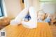 A woman in white stockings is sitting on a table.